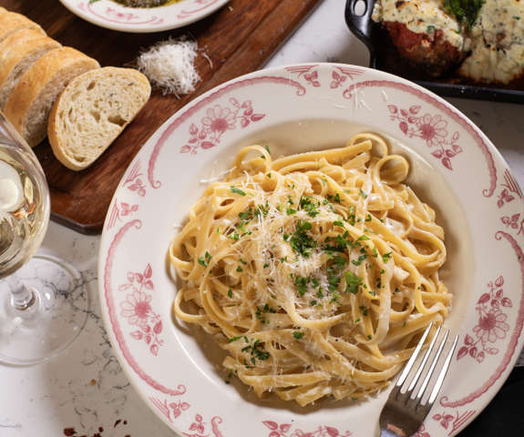 fettuccine pasta & full table of delicious food
